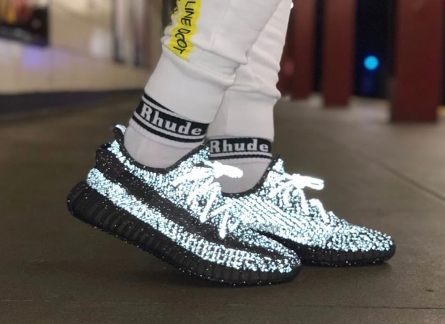 Yeezy Boost 350 V2 Black Reflective on feet with flash